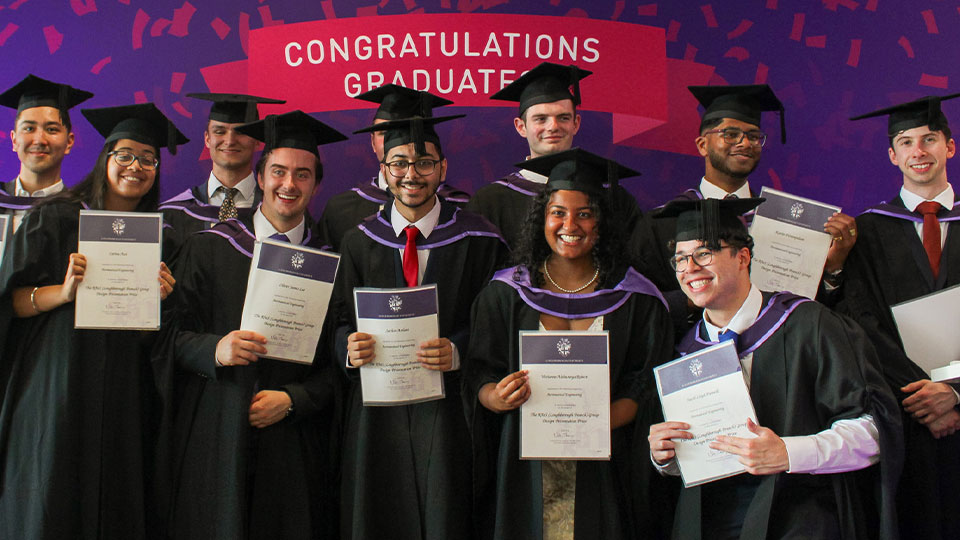 Group of graduates in cap and gown holding certificates